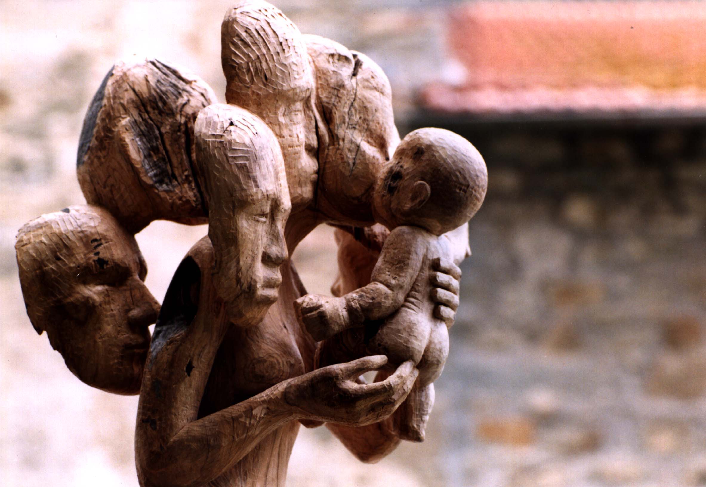 Scultura di Giorgio Piccini: figure che abbracciano un bambino, allegoria dell’umanità